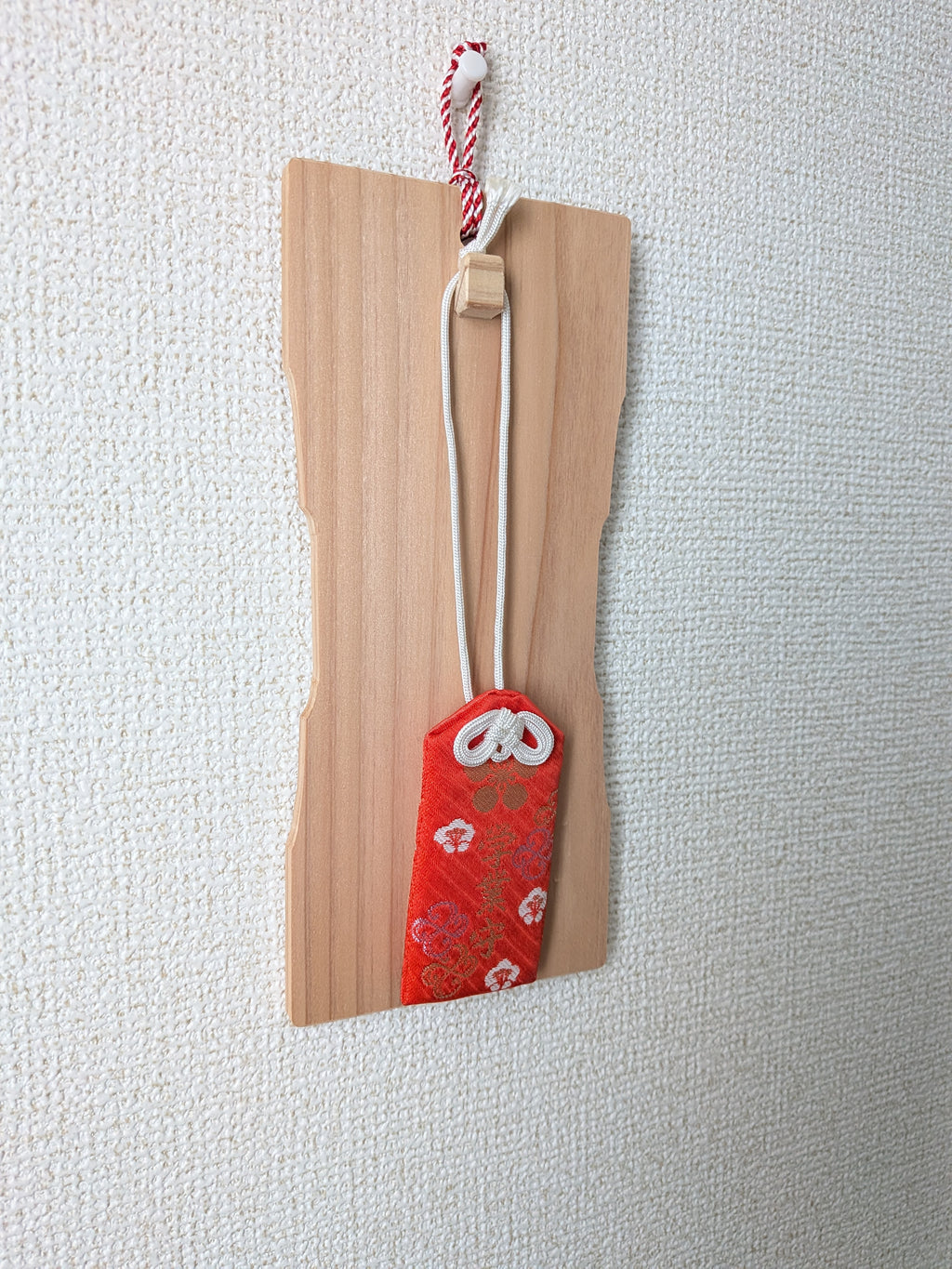 inori 壁掛けver.を斜めから見たところ。木の突起に赤いお守りの紐を掛けている
