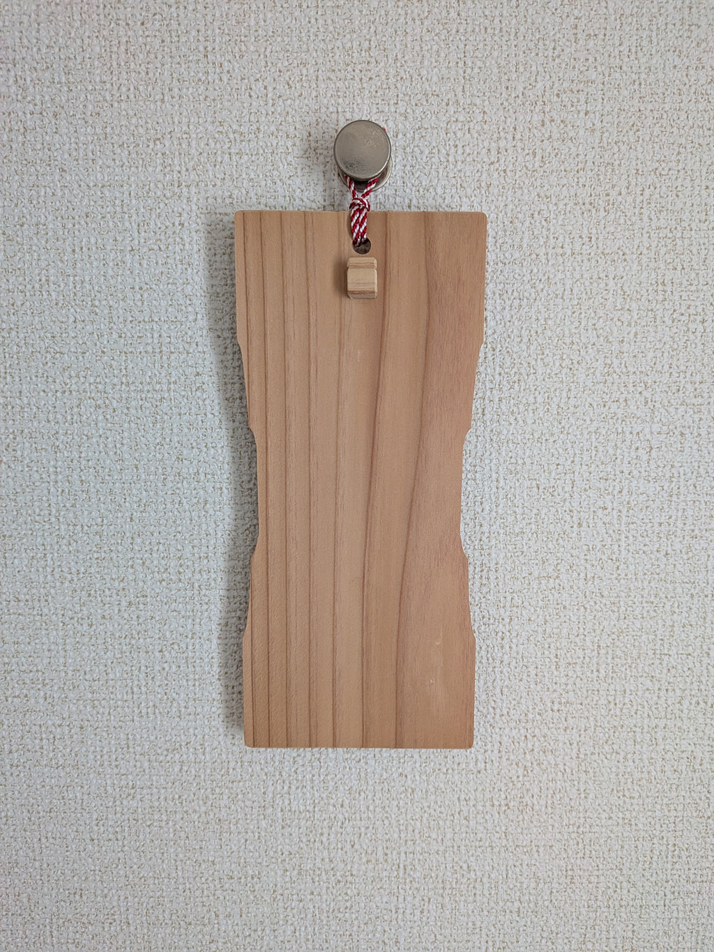 お守りを掛けていないinori 壁掛けver.を、金属のフックで壁に掛けたところ