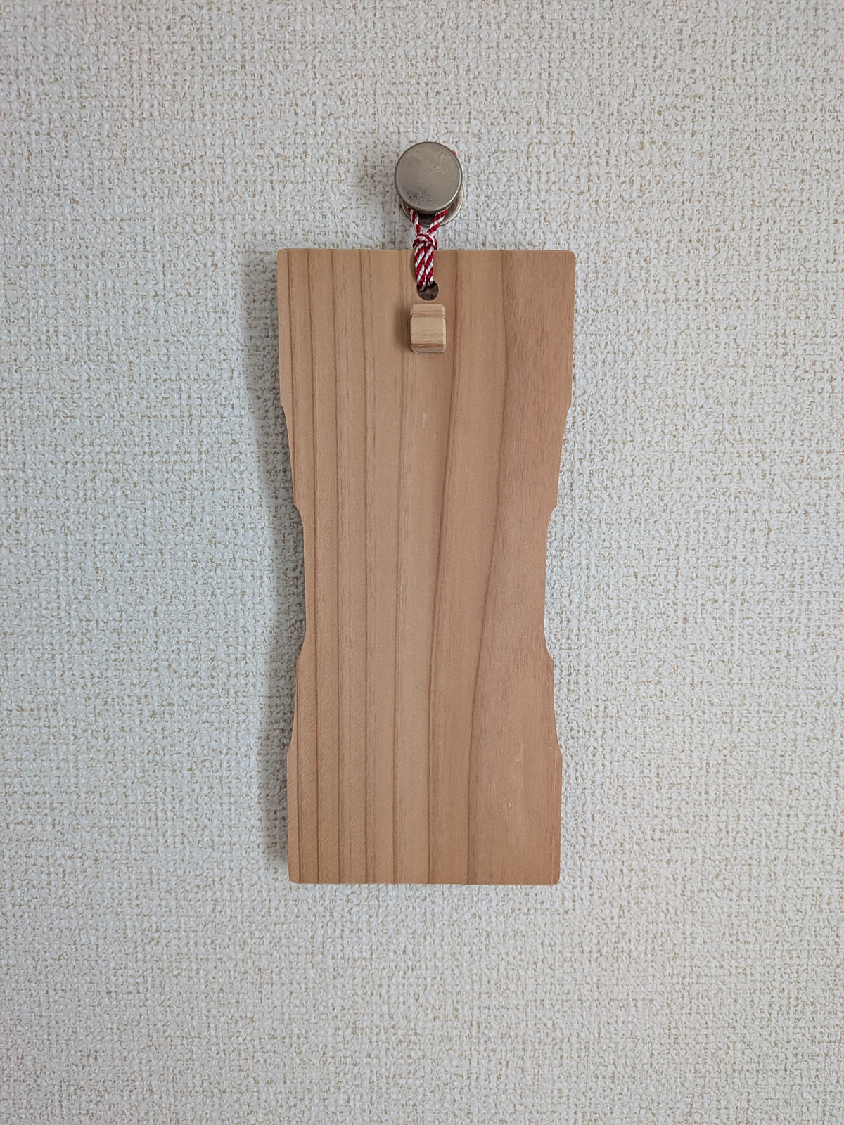 お守りを掛けていないinori 壁掛けver.を、金属のフックで壁に掛けたところ