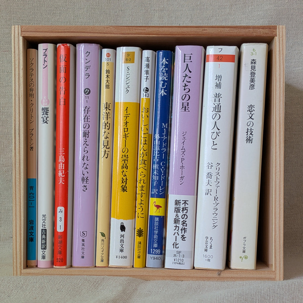 杉の箱に文庫本を11冊、背表紙を手前にして立てて並べた状態。箱いっぱいに収まっている