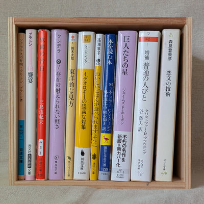 杉の箱に文庫本を11冊、背表紙を手前にして立てて並べた状態。箱いっぱいに収まっている
